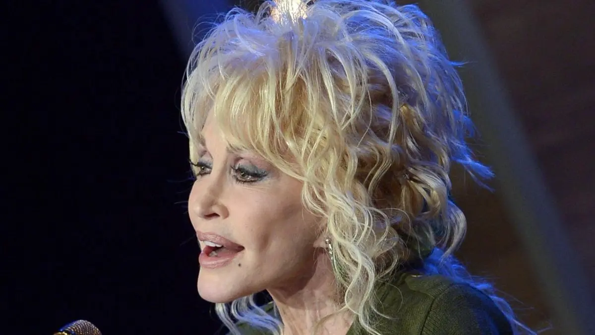 Dolly Parton wearing iconic outfit on stage